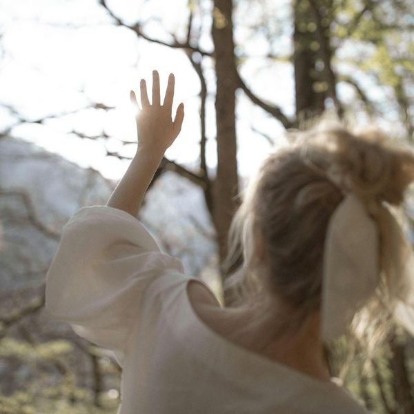 Serene woman meditating in a bright, peaceful environment.